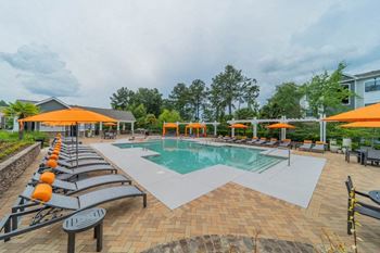 a pool with lounge chairs and umbrellas at the resort